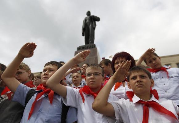 Школьники в пионерских галстуках около памятника Ленину